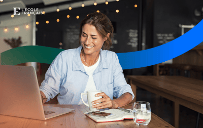 Femme avec une tasse à la main qui regarde un ordinateur