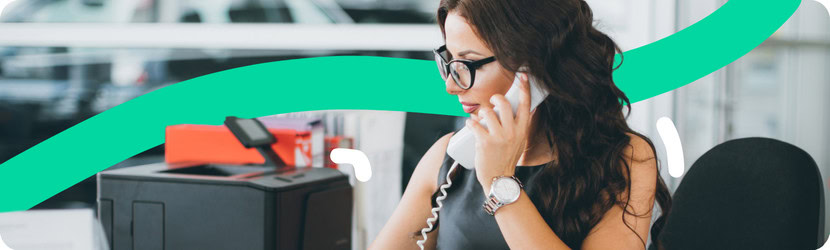 Femme au téléphone devant un ordinateur.
