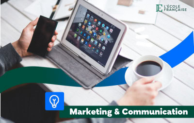 Personne devant une tablette avec un café et son téléphone à la main