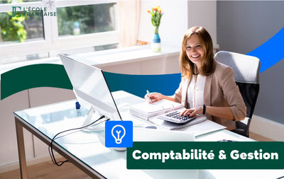 Femme tapant sur une calculatrice devant un ordinateur