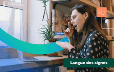 Femme pratiquant la LSF devant son ordi