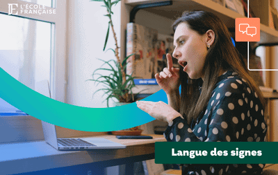 Femme pratiquant la LSF devant son ordi